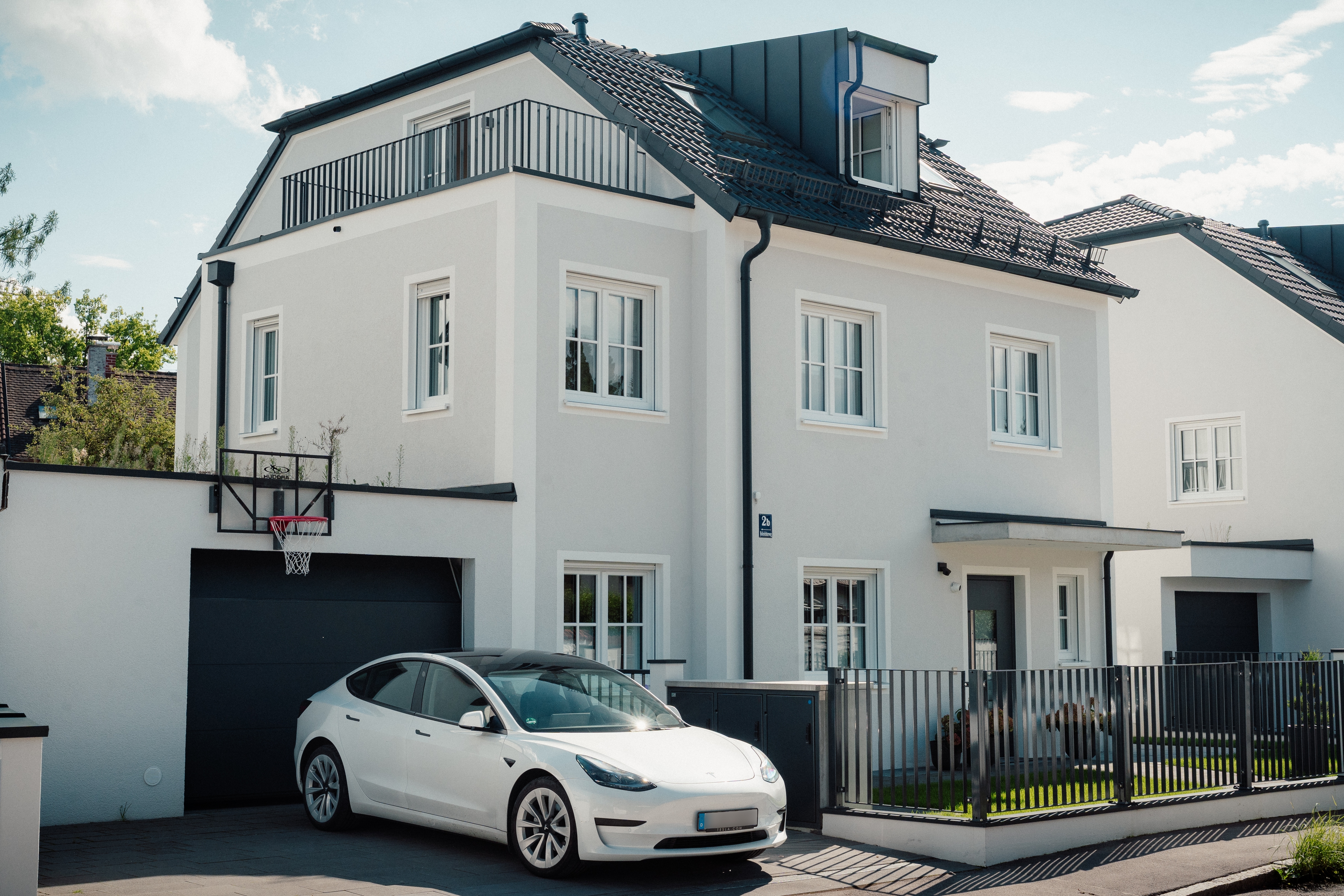 Hoferichterweg 2, 2a & 2b – modernes Stadthausensemble mit heller Fassade, Dachgauben, Garagen und Vorgartenzaun (Straßenansicht)